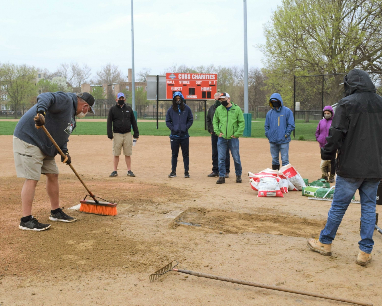 Brad Essary, regional sales manager for Turface Athletics, demonstrates proper field maintenance techniques to youth league volunteers during a field day at Warren Park.