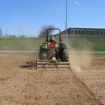 Tractor raking a field.